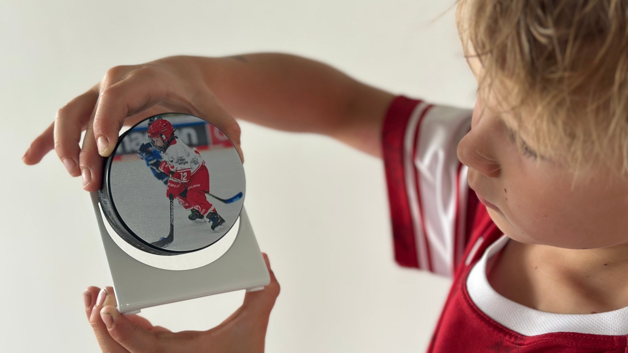 Kind hält Puckhalter mit Eishockey Puck und Spieler-Motiv